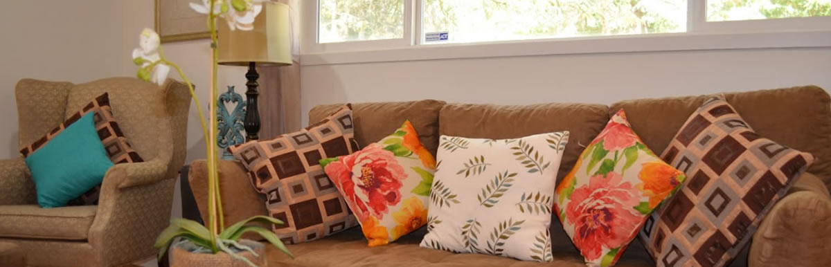 Living room sofa with bright floral cushions.