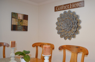 Dining room decorative wall hanging that says, 'Gather Here'.